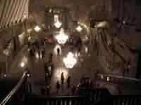 Large hall inside mine, with five chandeliers, grand staircase, carved walls, and several dozen people